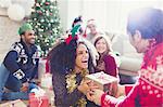 Enthusiastic friends exchanging Christmas gifts