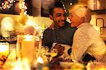 Affectionate couple with dog at candlelight Christmas table