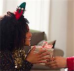 Enthusiastic girlfriend receiving Christmas gift from boyfriend