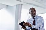 Pensive businessman with journal looking away