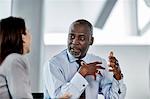 Businessman explaining to businesswoman in meeting