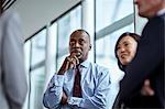 Attentive serious businessman listening to colleagues