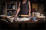 Valentine's Day baking, woman standing in a kitchen, rolling out dough with a rolling pin.