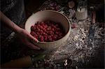 Valentine's Day baking. A bowl of fresh raspberries on a floury table.