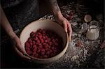 Valentine's Day baking. A woman preparing raspberries in a bowl.