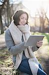 Mature woman using digital tablet in the park and smiling, Bavaria, Germany