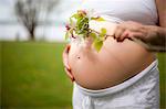 Pregnant woman holding cherry flowers standing at lakeside, Ammersee, Upper Bavaria, Bavaria, Germany