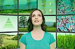 Portrait of young woman in front of graphical screens showing environmental images