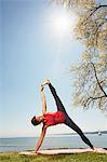 Woman with arm and leg raised in yoga position