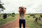 Woman enjoying ride on top of vehicle in wildlife park, Nairobi, Kenya