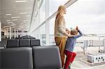 Mother and sons in departure lounge looking out of window