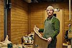 Portrait of male coffee shop owner holding coffee bean sack in store room
