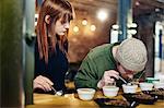 Coffee shop team smelling bowls of coffee and coffee beans at tasting