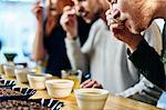 Team tasting bowls of coffee at coffee shop tasting