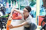 Woman in workshop checking recumbent bicycle bodywork