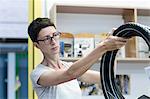 Woman in workshop checking bicycle tyres