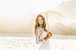 Portrait of beautiful woman holding parasol on sunlit beach, Cape Town, South Africa