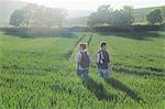 Rear view of couple hiking in field