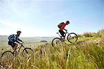 Cyclists cycling up hillside