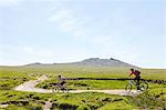 Cyclists cycling on hillside path