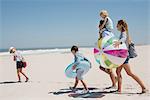 Couple walking on the beach with their children