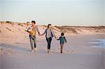 Family walking on the beach with holding hands of each other