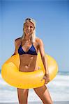 Happy young woman holding inflatable ring around her waist