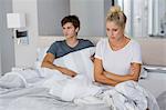 Young couple sitting on the bed with relationship difficulties