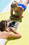 Female friends playing tic-tac-toe at the poolside