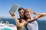 Attractive female friends taking selfie of themselves with a digital tablet
