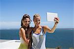 Female friends taking selfie for themselves with a digital tablet