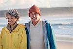 Happy senior couple standing on the beach