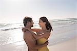 Happy young couple embracing each other on the beach