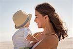 Happy mother with her little son enjoying on beach