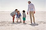 Happy grandparents with grandchildren enjoying on beach