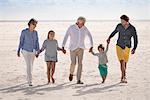 Happy multi-generation family walking on beach