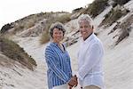 Happy senior couple standing on beach