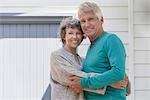 Loving senior couple embracing outside of house