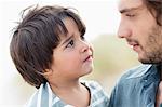 Close-up of a man and his son looking at each other