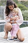 Happy mother playing with son at poolside