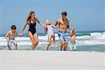 Happy family walking on the beach