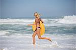 Pretty young woman carrying inflatable ring on the beach