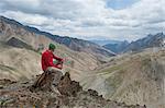 A trekker stops to admire the views from the top of the Konze La in the remote Himalayan region of Ladakh in northern India, India, Asia