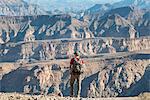 A man stands on the edge of the Fish River Canyon, Namibia, Africa