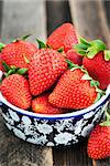 Fresh organic ripe strawberry in a bowl on wooden table