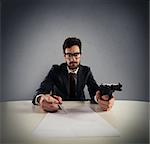 Man with gun and pen to sign