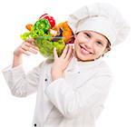 smiling little girl-cook with bowl of vegetables on shoulder isolated on white background