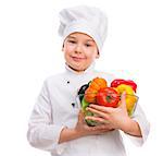 funny little boy-cook in uniform holding bowl with vegetables in hands isollated on white background