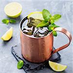 Cold Moscow Mules cocktail with ginger beer, vodka, lime Grey stone background