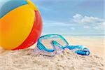 Beach ball and goggles in the sand at the beach